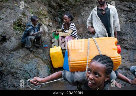 Straße zwischen Wukro nach Mekele, Äthiopien. Auf dem Weg zwischen Wukro und Mekele mehrere Menschen Wasser zu sammeln und nutzen Sie die Gelegenheit zum Baden in einem s Stockfoto