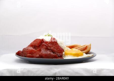 Foto von frisch gekochtem Tocino oder gehärtetem Schweinefleisch, serviert mit gebratenem Reis und Ei mit Gemüse. Stockfoto