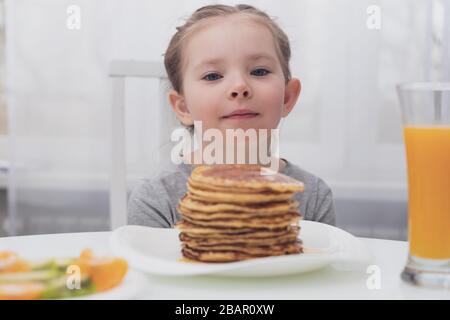 Kleines hübsches Mädchen, das Frühstück isst, drinnen Stockfoto