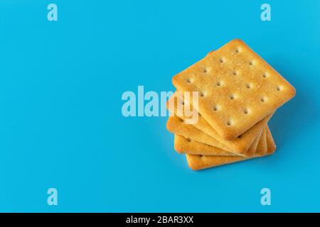 Knuspriger Cracker auf blauem Hintergrund. Salzige Teekekse. Gesunder Diät-Snack. Stockfoto