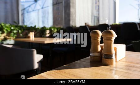 Nahaufnahme von Salz und Pfeffer auf Holztisch im modernen Restaurant Stockfoto