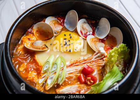 Kimchi jjigae oder Kimchi Stew ist ein koreanisches Gericht, das mit Kimchi und anderen Zutaten, wie zum Beispiel Hengste, Zwiebeln, gewürfelten Tofu, Schweinefleisch, Thunfisch und Meeresfrüchte, zubereitet wird. Stockfoto