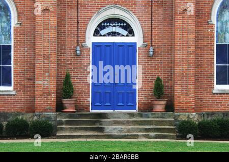 Ein Paar schöne blaue Türen in einer alten Ziegelkirche Stockfoto