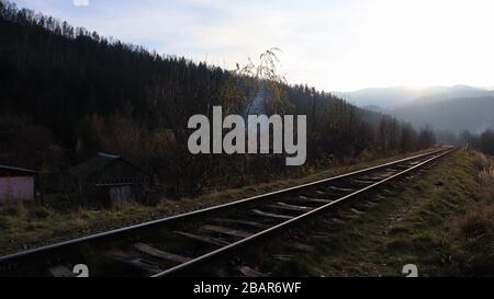 Nahaufnahme der Tracks. Zwei Bahngleise verschmelzen eng. Vintage-Ton. Schienen und Holzschwellen Stockfoto