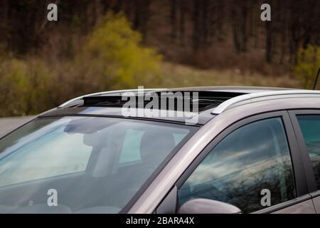 Doppelte Panoramadachluke, montiert auf luxuriösem SUV. Windabweiser mit halbgleitenden Schiebedach. Luftaufnahme von der wunderbaren Wirkung des Dachs. Stockfoto
