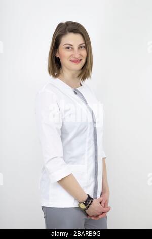 Junges Mädchen ist ein Arzt europäischer Erscheinung, vor dem Hintergrund einer Lichtwand. Stockfoto