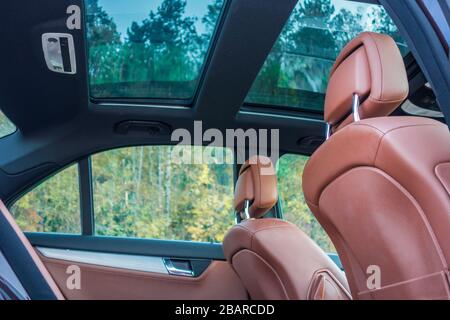 Mercedes Benz W204-Innenraum mit Vorder- und Rücksitzen, Fahrer und Beifahrer, Teil vom Lenkrad, Vorhang hinten, braunes Leder, Stockfoto