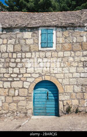 Traditionelles Steinhaus mit blauer Tür und Fenster in Kroatien Stockfoto