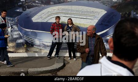 Die Fans gehen an den Schlaufen vorbei, die einen Künstlereindruck von den Plänen der Vereine zeigen, ein neues Stadion neben der White hart Lane zu bauen Stockfoto