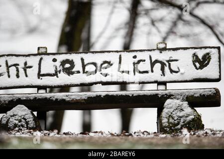 Bielefeld, Deutschland. März 2020. Auf der Lehne einer Bank, die auf einem Wanderweg im Teutenburger Wald steht, wurden im Schnee die Worte "Ohrenlicht" und ein Herz gemalt. Nach dem frühlingsartigen Wetter der vergangenen Tage mit zweistelligen Temperaturen schneit es in Teilen von Nordrhein-Westfalen. Credit: Friso Gentsch / dpa / Alamy Live News Stockfoto