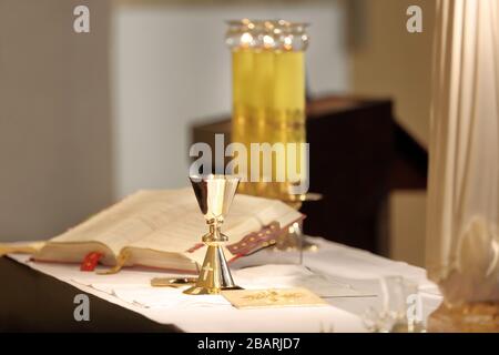 Kelch auf dem Altar und Römisches Missale im Hintergrund Stockfoto