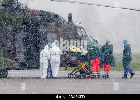 29. März 2020, Nordrhein-Westfalen, Mülheim an der Ruhrgebiet: Ein Patient wird am Flughafen von einem Militärhubschrauber zu einem Rettungswagen transportiert. Insgesamt sollen zwei Patienten von der französischen Metz-Klinik ins Essener Universitätsklinikum gebracht werden. Foto: Marcel Kusch / dpa Stockfoto