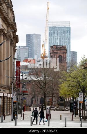 Käufer gehen durch einen ruhigen St Ann's Square, Manchester, während Großbritannien weiterhin in Sperrungen bleibt, um die Ausbreitung des Coronavirus einzudämmen. Stockfoto