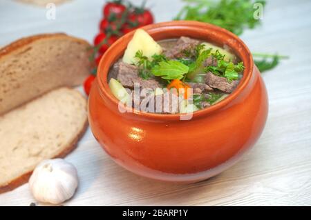 Braten Sie in einem Topf mit Rindfleisch und Kartoffeln auf dem Tisch Stockfoto