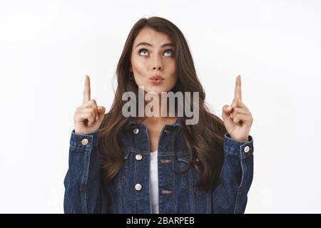 Waist-up Portrait neugierig und interessiert, amüsiert kaukasischen Frau Check-out etwas Interessantes, zeigt die Finger nach oben, Falten Lippe nach oben Stockfoto