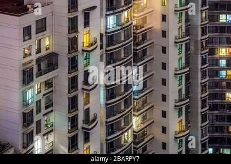 Nahansicht des Hochhauses bei Nacht. Bunte, Beleuchtete Fenster. Wohnhäuser in der Innenstadt von Shanghai, China. Stockfoto