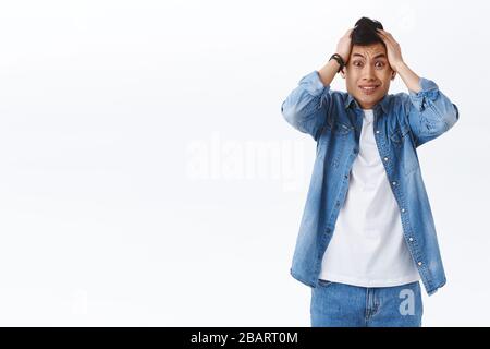 Geez, was habe ich getan. Portrait des ängstlichen jungen verlegen asiaten greifen Kopf in Panik, schütteln es in Verleugnung fühlen frustriert und nervös, haben riesig Stockfoto