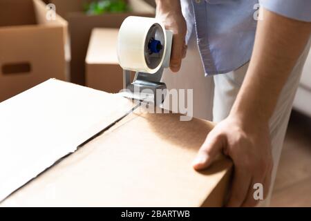 Nahaufnahme von jungen Männern, die Sachen in Kartons packen. Stockfoto