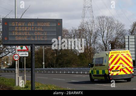 Leicester, Leicestershire, Großbritannien. März 2020. Ein Krankenwagen wird an einem Zeichen vorbeigefahren, das die Menschen dazu ermutigt, zu Hause in Leicester während der Coronavirus Pandemie zu sagen. Credit Darren Staples/Alamy Live News. Stockfoto