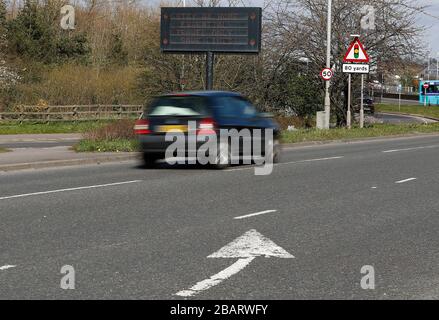 Leicester, Leicestershire, Großbritannien. März 2020. Ein Auto wird an einem Zeichen vorbeigefahren, das die Menschen dazu ermutigt, zu Hause in Leicester während der Coronavirus Pandemie zu sagen. Credit Darren Staples/Alamy Live News. Stockfoto