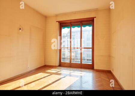 Sonniges Zimmer mit Holzboden im Inneren der alten Wohnung Stockfoto