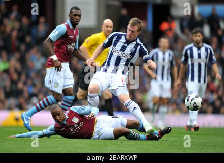 Der Fabian Delph von Aston Villa rutscht in West Bromwich Albion Chris Brunt ein Stockfoto