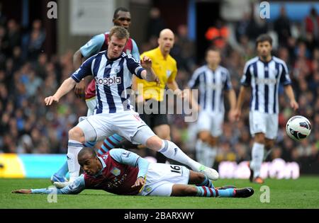 Der Fabian Delph von Aston Villa rutscht in West Bromwich Albion Chris Brunt ein Stockfoto