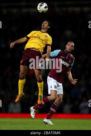 Arsenals Mikel Arteta leitet den Ball vor dem Andy Carroll von West Ham United Stockfoto