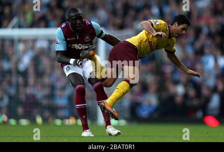 Arsenals Mikel Arteta wird von West Ham United's Mohamed Diame aufgepeppt Stockfoto