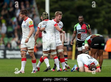 Saracens Spieler feiern nach dem Abpfiff, während Harlequins Spieler niedergeschlagen bleiben Stockfoto