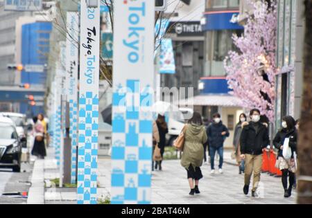 Tokio, Japan. März 2020. Fußgänger, die Gesichtsmasken tragen, gehen am Sonntag, 29. März 2020 im Einkaufsviertel Ginza in Tokio, Japan. Straßen in normalerweise belebten Tokioter Gegenden wie dem Shibuya-, Shinjuku- und dem Ginza-Einkaufsviertel sind unfrequent bevölkert. Foto von Keizo Mori/UPI Credit: UPI/Alamy Live News Stockfoto