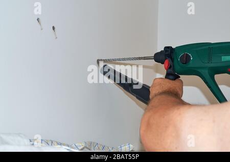 Bohren eines Lochs in einer Betonwand und Staubsaugen von Staub während des Prozesses Stockfoto