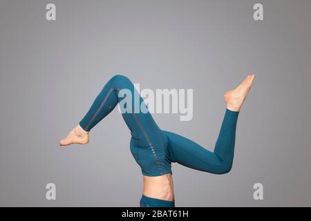 Nahaufnahme von sportlicher Frau, die einen Kopfstand macht, Studio. Stockfoto