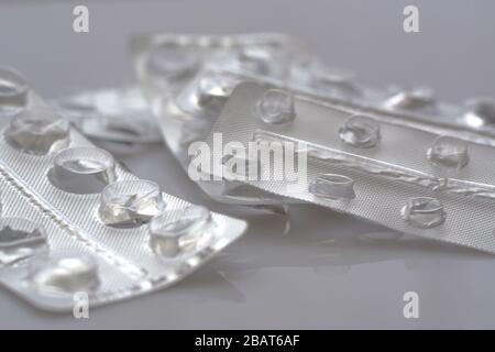 Ein Haufen benutzte leere Blisterpackungen mit Tabletten, die ohne Pillen auf grauem Hintergrund geöffnet und leer waren. Medizinisches und medizinisches Konzept Stockfoto