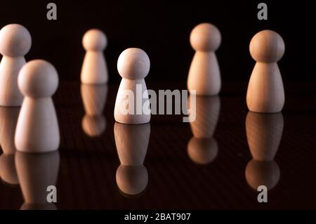 Viele Holzpfennige und auf schwarzem Hintergrund. Soziale Distanzierung Stockfoto