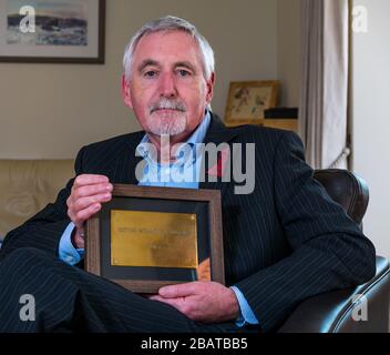 Dr. Mike Ewart, Direktor des Scottish International Education Trust, der von Sir Sean Connery gegründet wurde, hält SIET's Büro Door Plaque, Schottland, Großbritannien Stockfoto