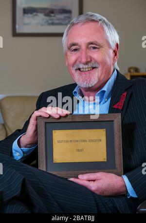 Dr. Mike Ewart, Direktor des Scottish International Education Trust, der von Sir Sean Connery gegründet wurde, hält SIET's Büro Door Plaque, Schottland, Großbritannien Stockfoto