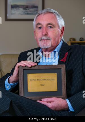 Dr. Mike Ewart, Direktor des Scottish International Education Trust, der von Sir Sean Connery gegründet wurde, hält SIET's Büro Door Plaque, Schottland, Großbritannien Stockfoto