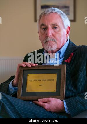 Dr. Mike Ewart, Direktor des Scottish International Education Trust, der von Sir Sean Connery gegründet wurde, hält SIET's Büro Door Plaque, Schottland, Großbritannien Stockfoto