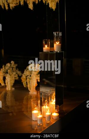 Hochzeitsaltar mit vielen brennenden Süßigkeiten in der Nacht. Stockfoto