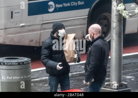 New York, USA. März 2020. Die Menschen tragen Gesichtsmasken, während sie während der Coronavirus-Krise in New York gehen, um Lebensmittel zu kaufen. Kredit: Enrique Shore/Alamy Live News Stockfoto