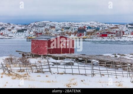 Zäune für die Tierhaltung und eine rote Bühne im historischen Fischerdorf Tilting, auf Fogo Island in Neufundland, Kanada [keine Eigentumsfreigabe; verfügbar Stockfoto