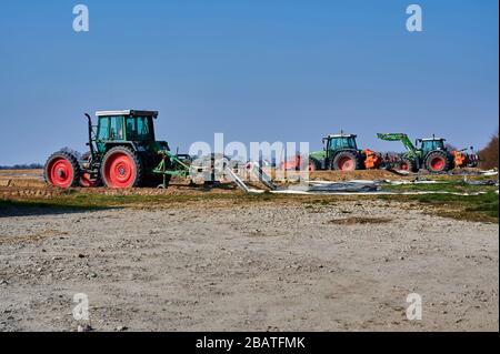 Brandenburg, Deutschland - 28. März 2020: Blick auf Traktoren und Maschinen, die bereit sind, in Deutschland ein Spargelfeld für den Anbau vorzubereiten. Stockfoto