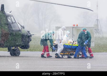 29. März 2020, Nordrhein-Westfalen, Mülheim an der Ruhrgebiet: Ein Patient wird am Flughafen von einem Militärhubschrauber zu einem Rettungswagen transportiert. Insgesamt sollen zwei Patienten von der französischen Metz-Klinik ins Essener Universitätsklinikum gebracht werden. Foto: Marcel Kusch / dpa Stockfoto