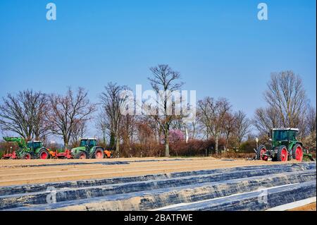 Brandenburg, Deutschland - 28. März 2020: Blick auf Traktoren und Maschinen, die bereit sind, in Deutschland ein Spargelfeld für den Anbau vorzubereiten. Stockfoto