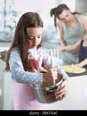 Fröhliche Familie, die köstliche Crepes in der Hausküche zubereitet Stockfoto
