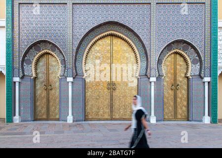 Eine junge verschleierte Frau, die vor dem Tor des Königlichen Palastes in Fes spaziert Stockfoto