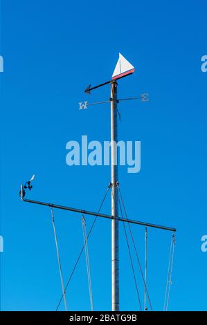 Nahaufnahme von Weathervane auf dem maritimen Flaggenmast mit blauem Himmelshintergrund im Newport Boat Club, Newport, Pembrokeshire. Wales. GROSSBRITANNIEN Stockfoto