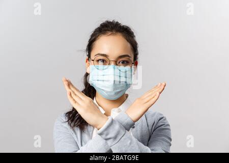 Covid19, Konzept für Virus, Gesundheit und Medizin. Es ist wichtig, nicht mehr nach draußen zu gehen, soziale Distanzierung und Quarantäne zu verhindern, und Mädchen in medizinischer Maske bittet die Menschen Stockfoto