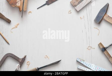 Holzbearbeitungswerkzeuge auf einer weißen Holztischzusammensetzung. Kopierbereich in der Mitte. Draufsicht, flacher Lay Stockfoto